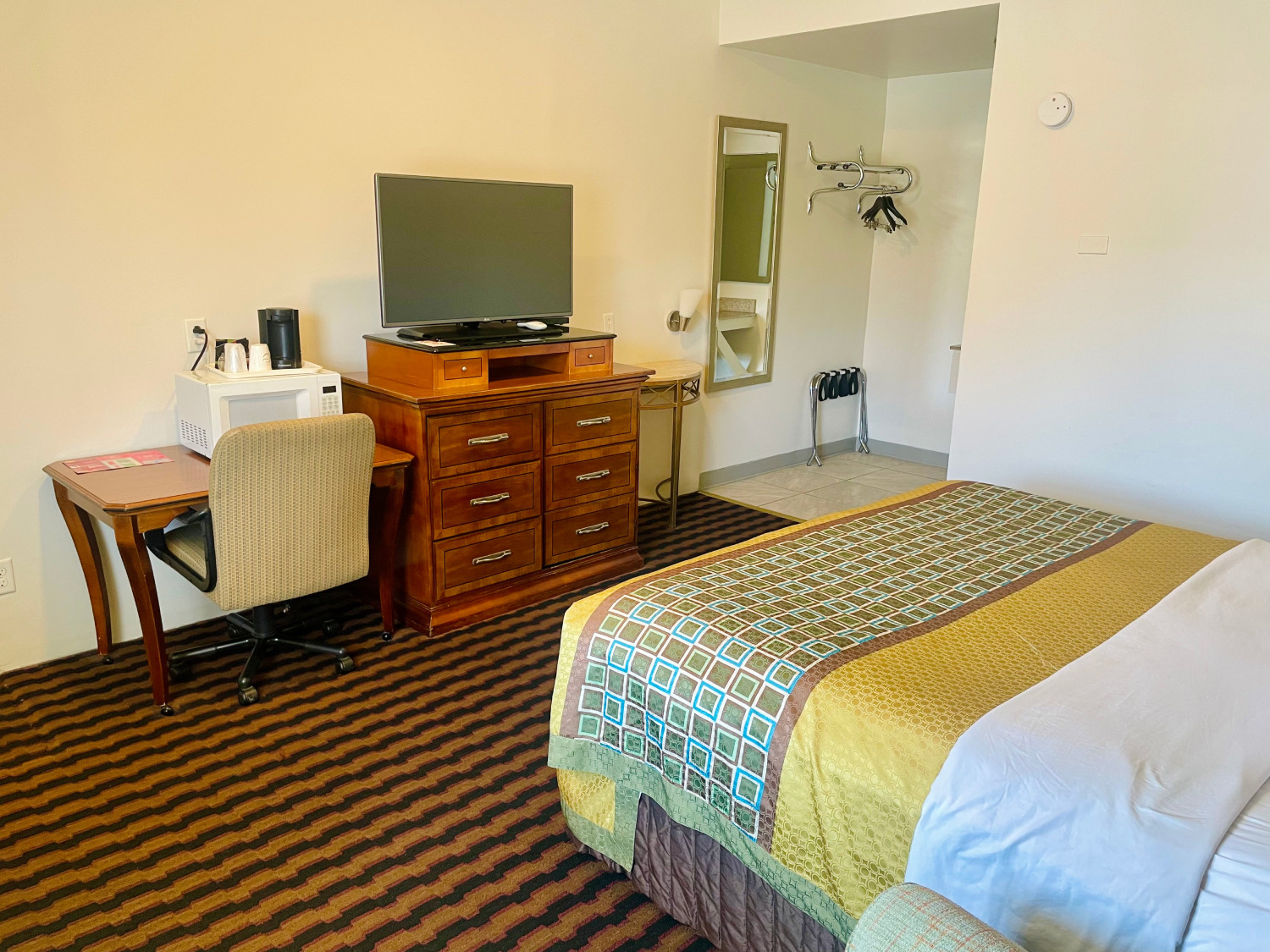 hotel room with a double bed, nightstand, and chair